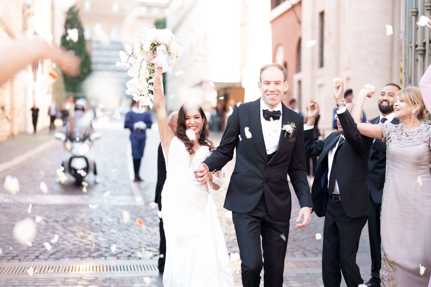 Wedding party walking and celebrating outside on a sunny day.