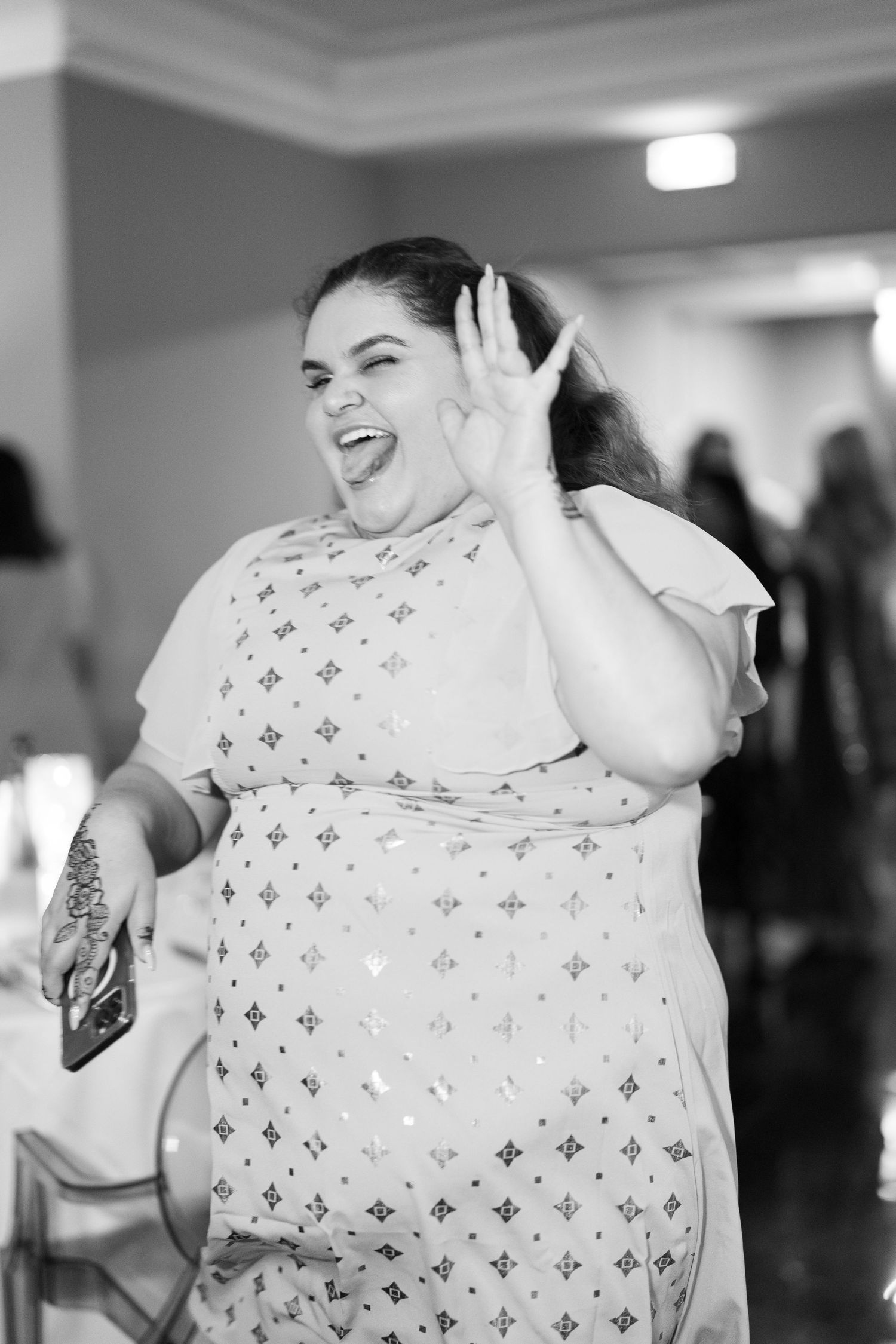 A sequence of joyful expressions and laughter while wearing a white patterned top.