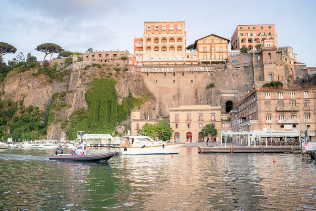 Historic waterfront buildings and boats along Mediterranean coastline.