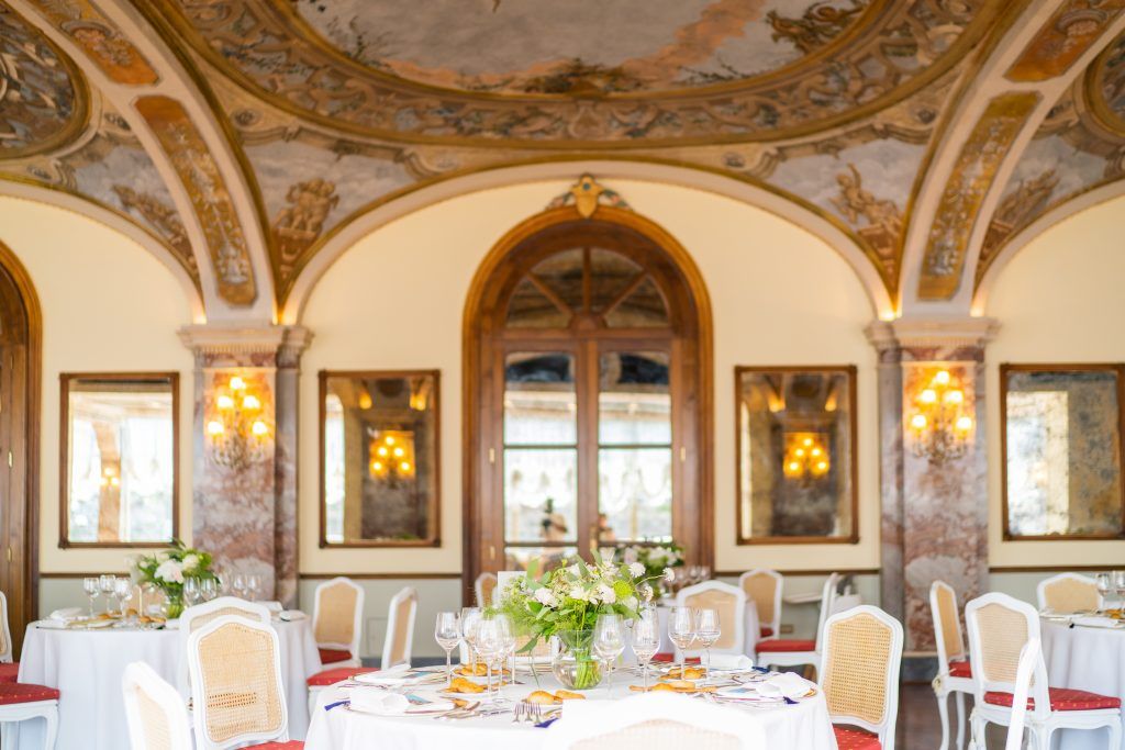 Ornate gilded ceiling and crystal chandeliers in luxury European ballroom.