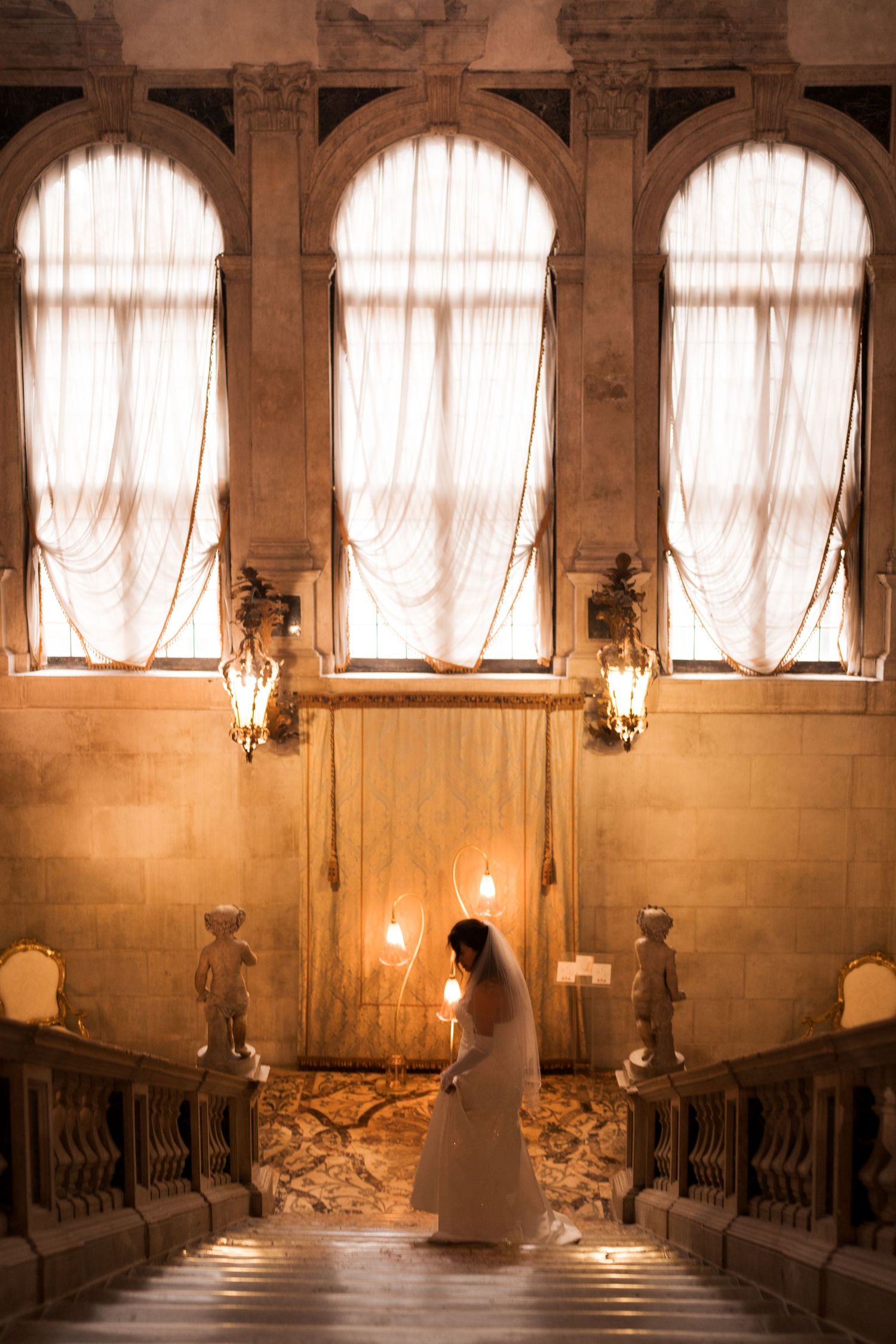 A sequence of four photos showing a figure in white walking through an elegant historic hallway with arched windows.