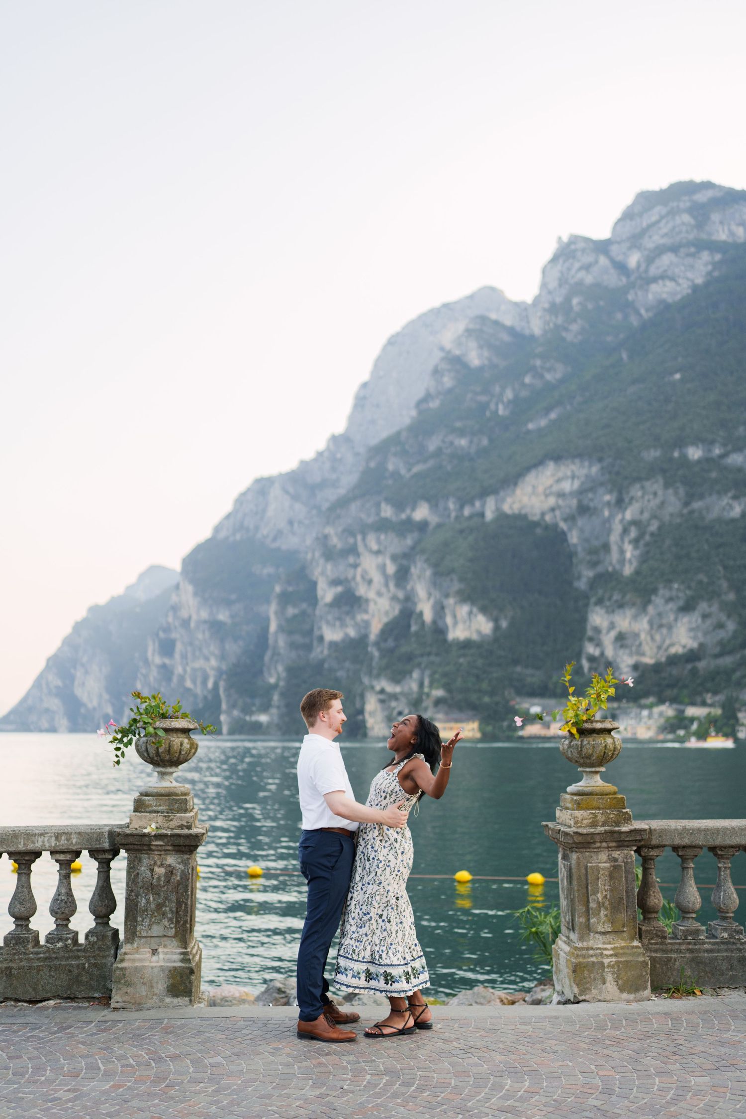 Couple walking together along the waterfront after their proposal in Riva del Garda