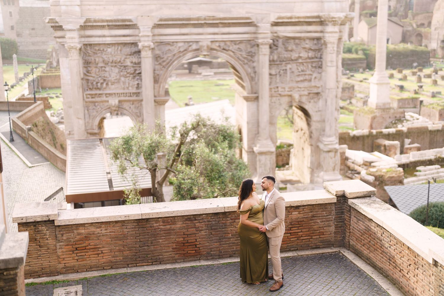 Couple embracing near the Arch of Septimius Severus at the Roman Forum in Rome, Italy.