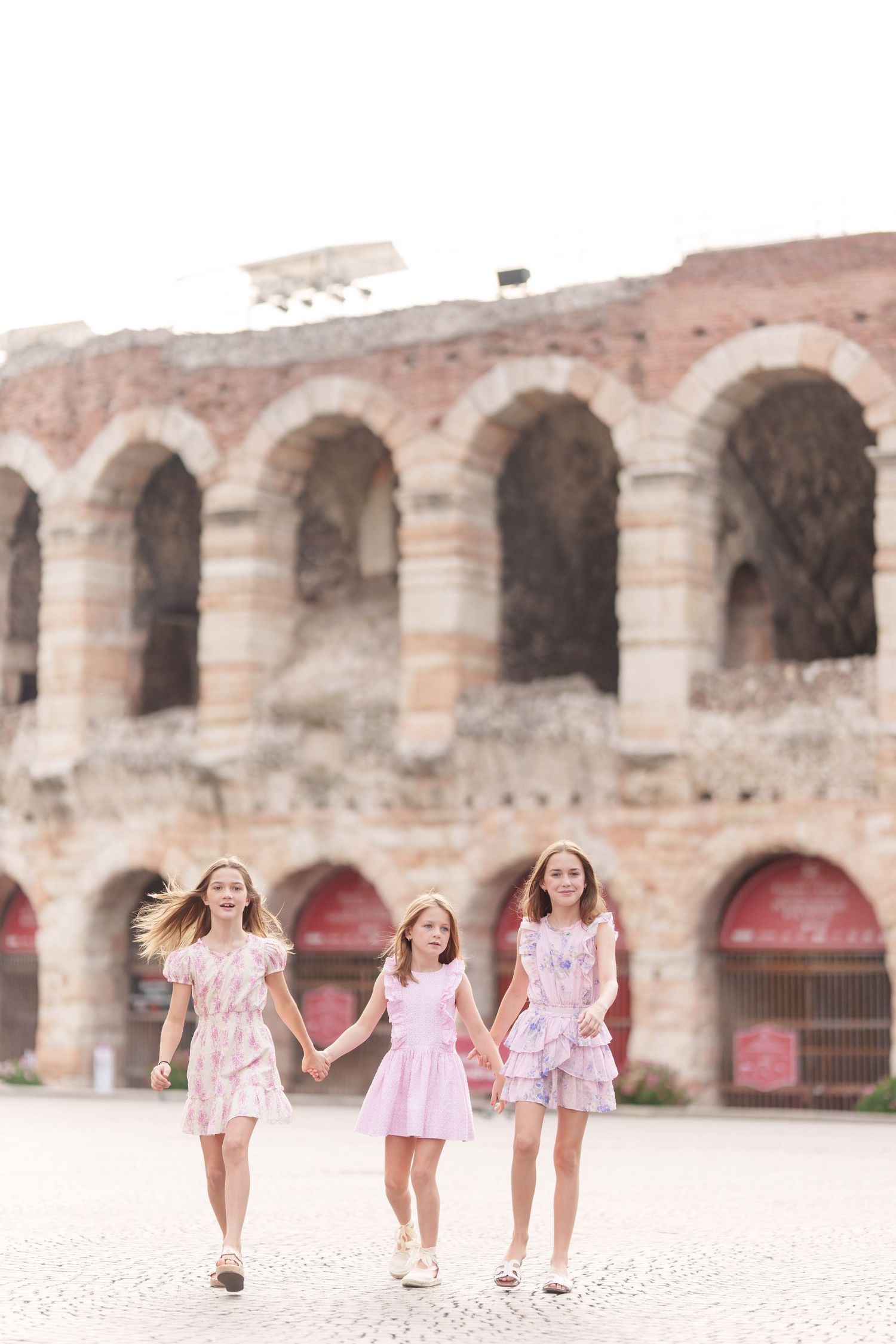 Verona family photographer family walking in front of Verona Arena Italy
