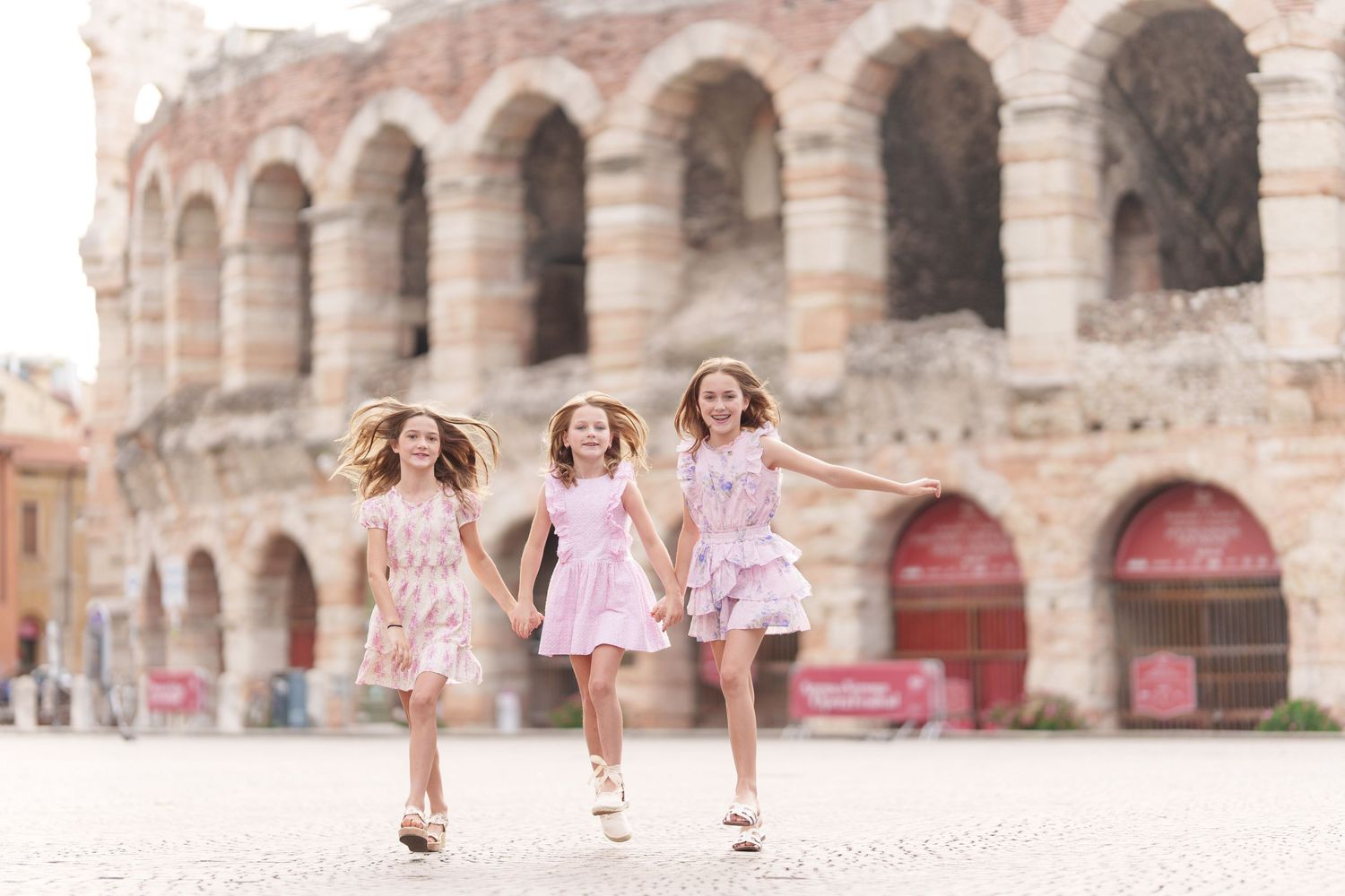 Verona family photographer family walking in front of Verona Arena Italy