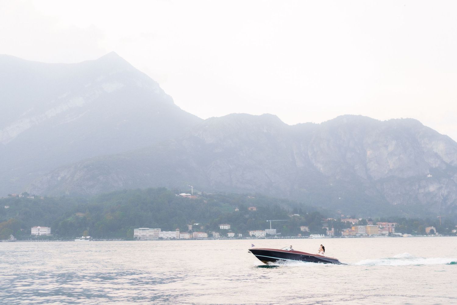 A series of panoramic photos showing a whale breaching in coastal waters with mountains in the background.