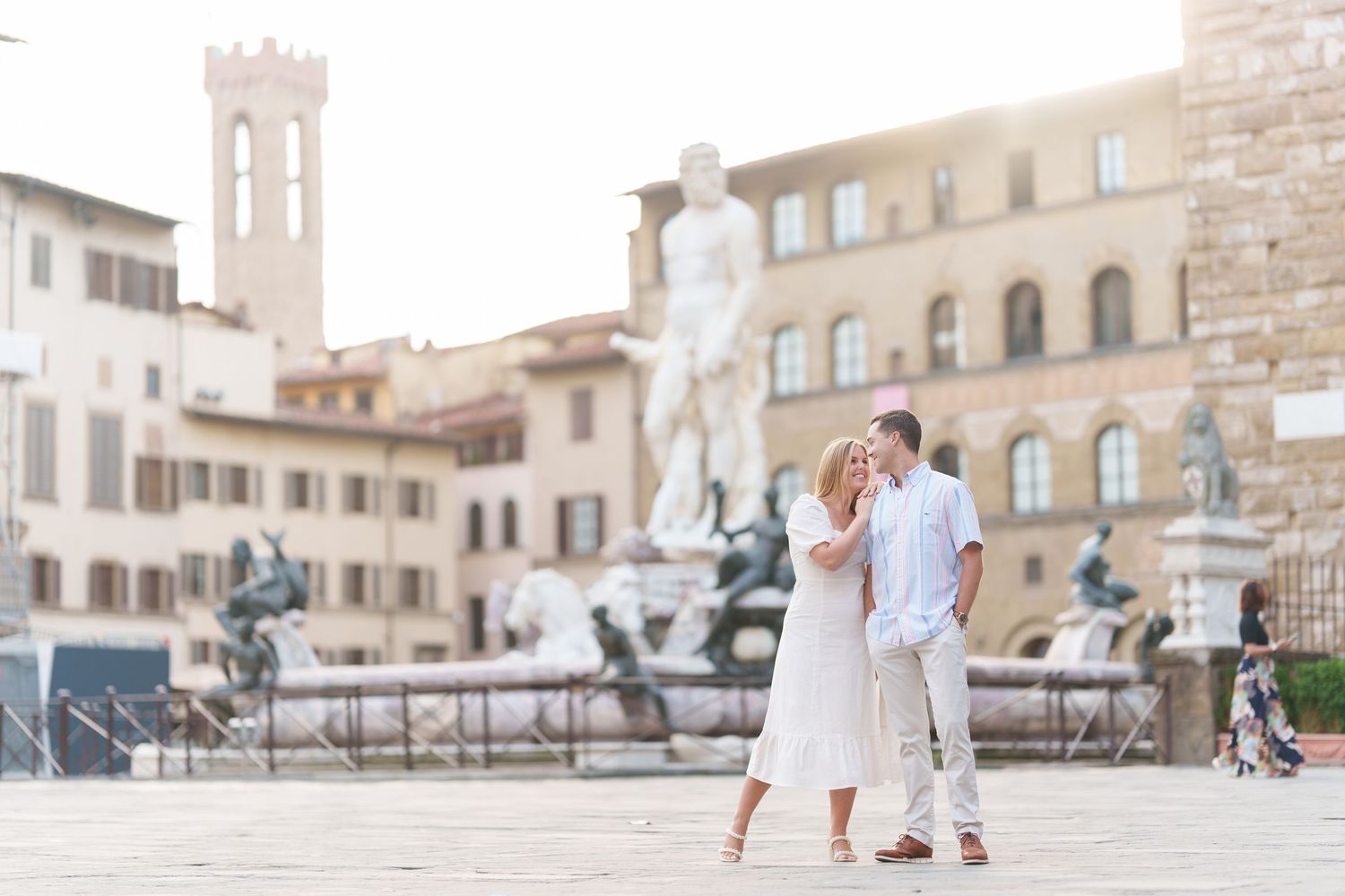 A couple shares a romantic moment in front of historic Italian architecture at Piazza della Signoria in Florence.