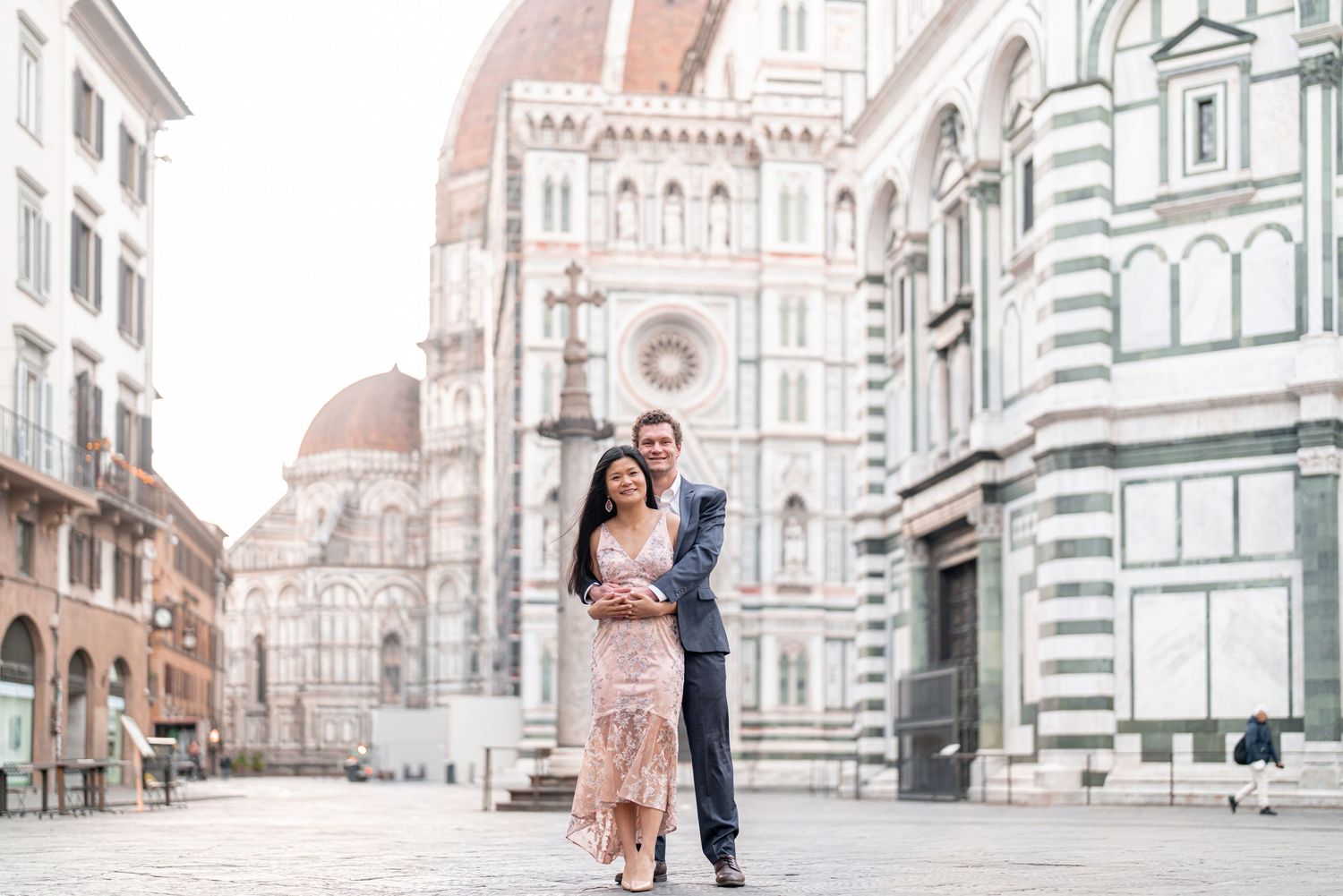 Romantic couple shares an intimate moment in front of Florence's historic Duomo cathedral in Italy.