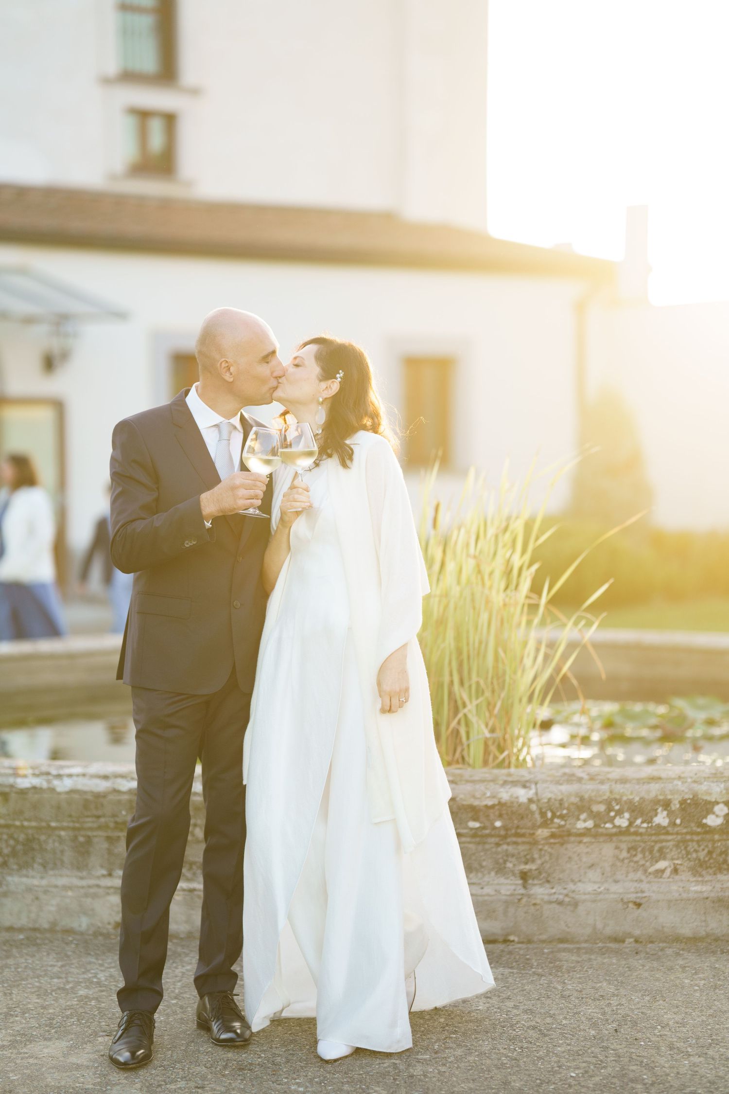 A couple celebrates their wedding day with a champagne toast in the golden evening light.
