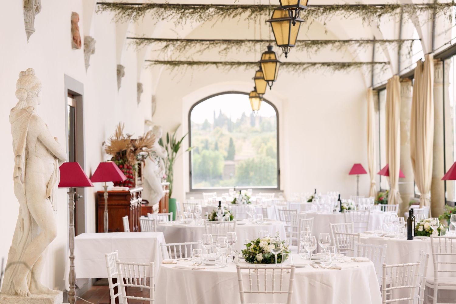 Elegant white wedding reception venue with classic lantern lighting and floral arrangements.
