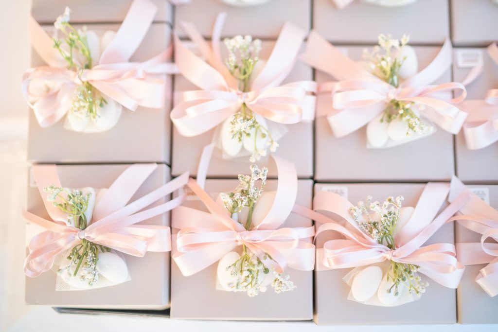 Delicate pink and white wedding favor boxes arranged in a repeating pattern.