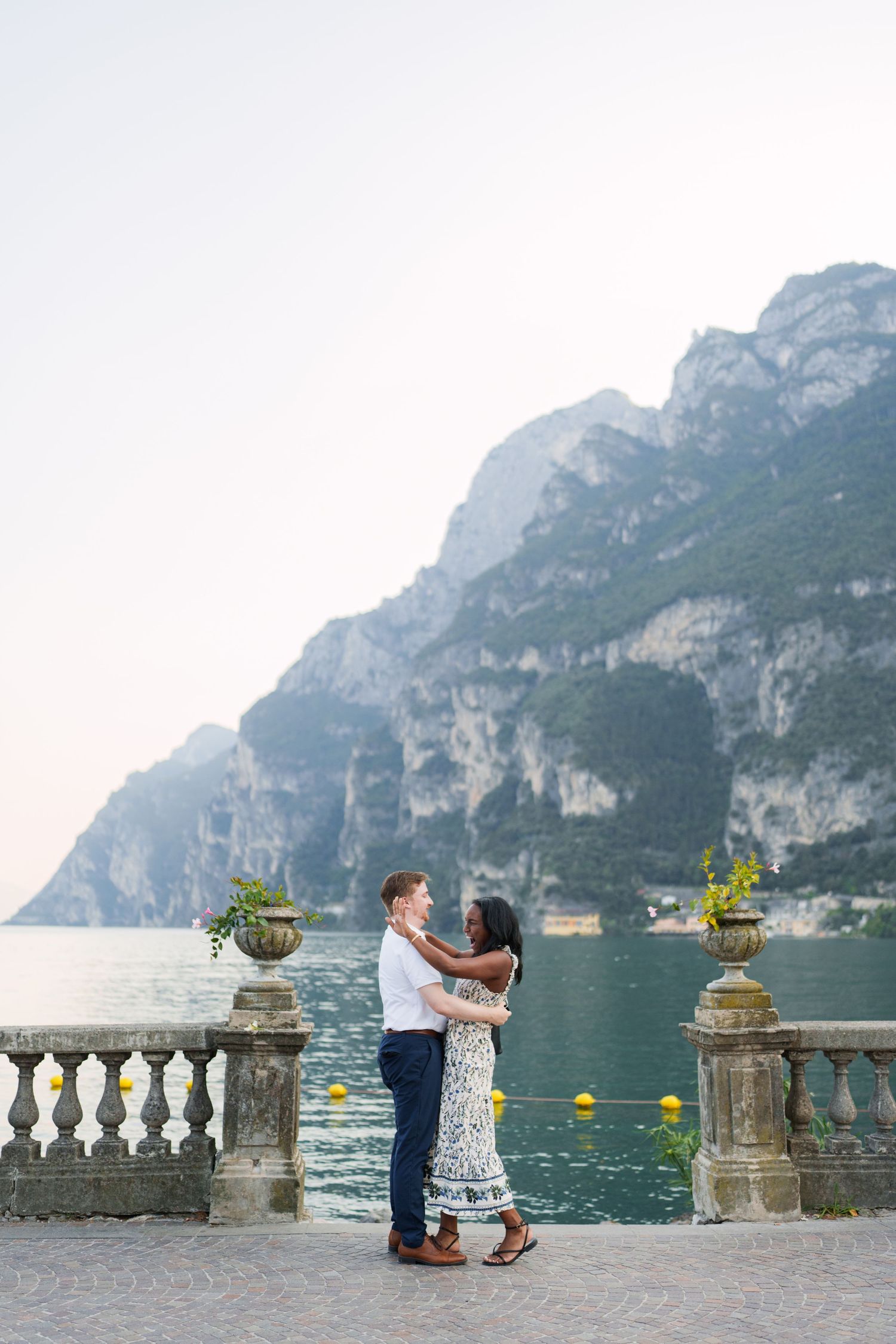 Couple walking together along the waterfront after their proposal in Riva del Garda