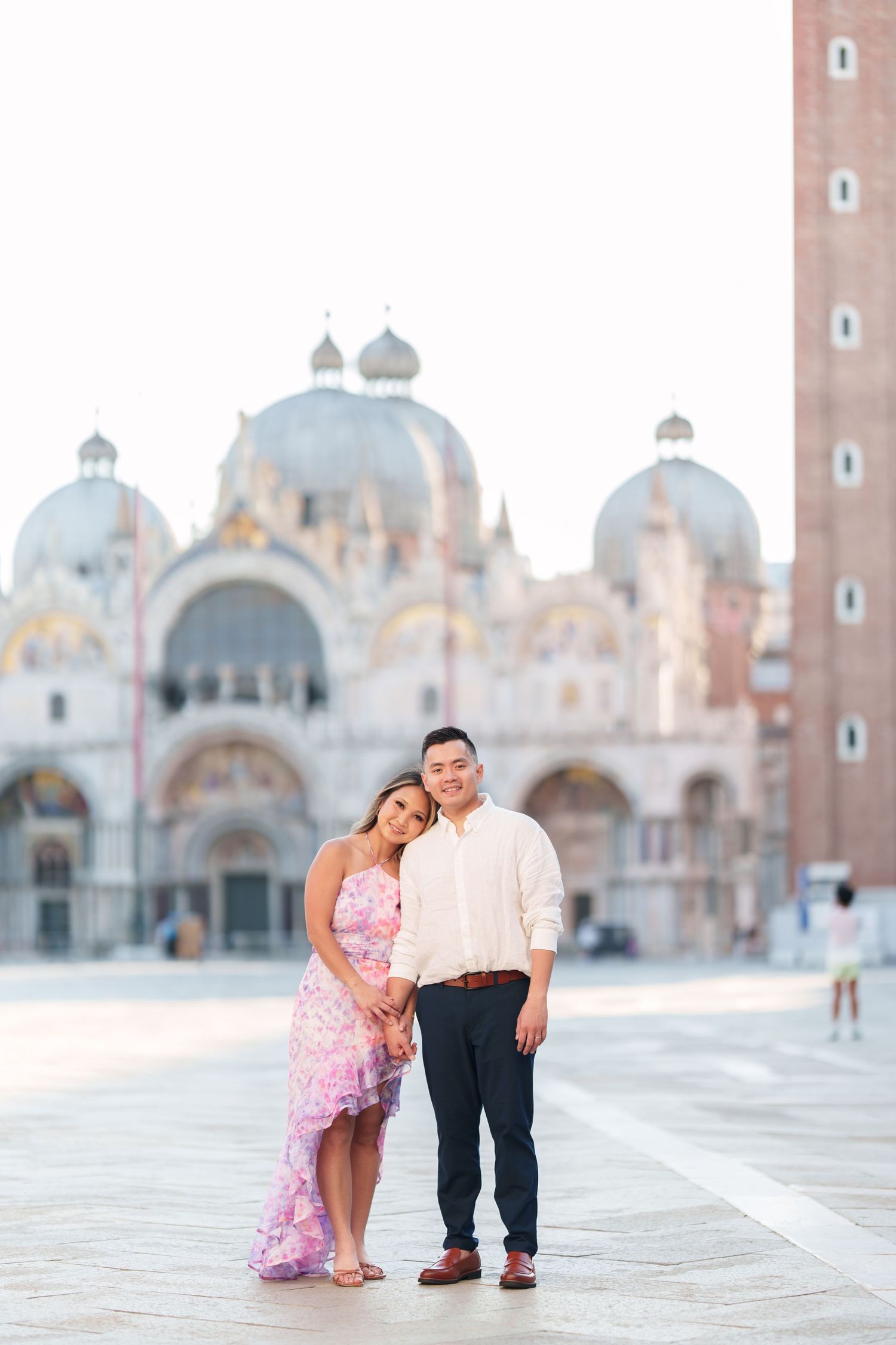 Couple posing in St. Mark's Square, Venice, with the iconic Basilica di San Marco in the background.