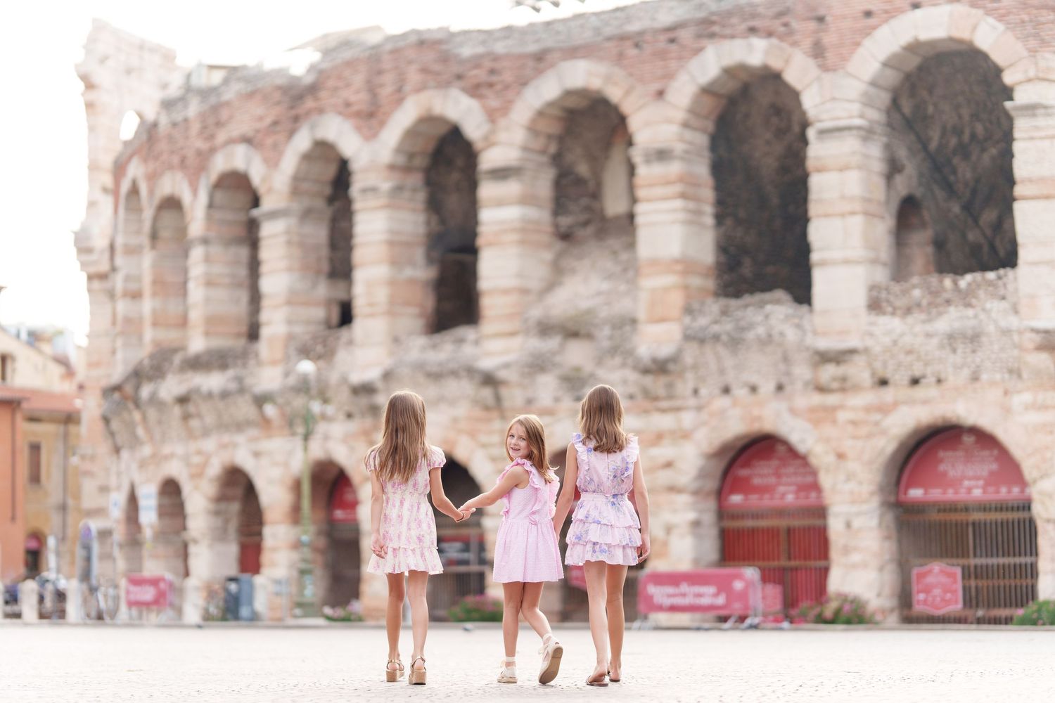 Verona family photographer family walking in front of Verona Arena Italy