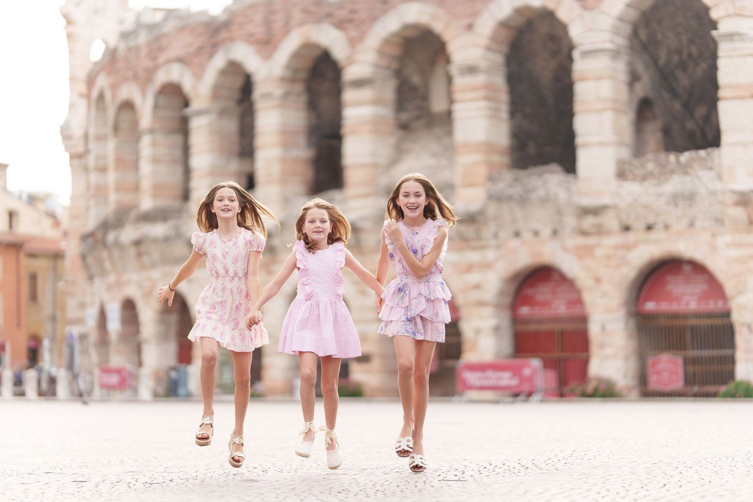 Verona family photographer family walking in front of Verona Arena Italy