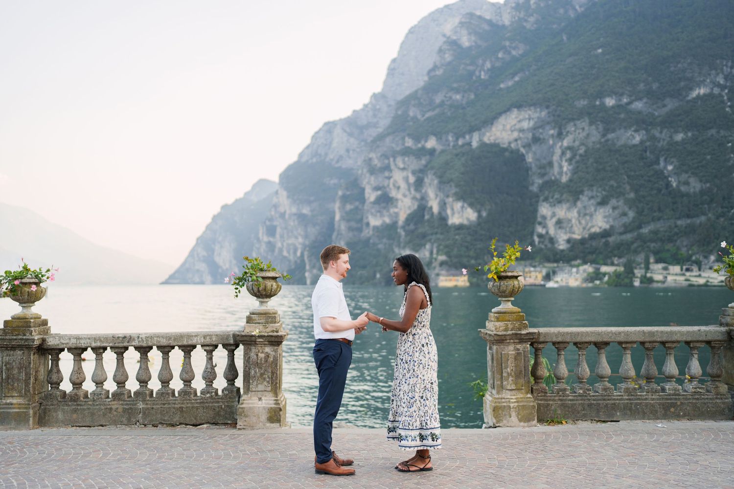 Couple walking together along the waterfront after their proposal in Riva del Garda