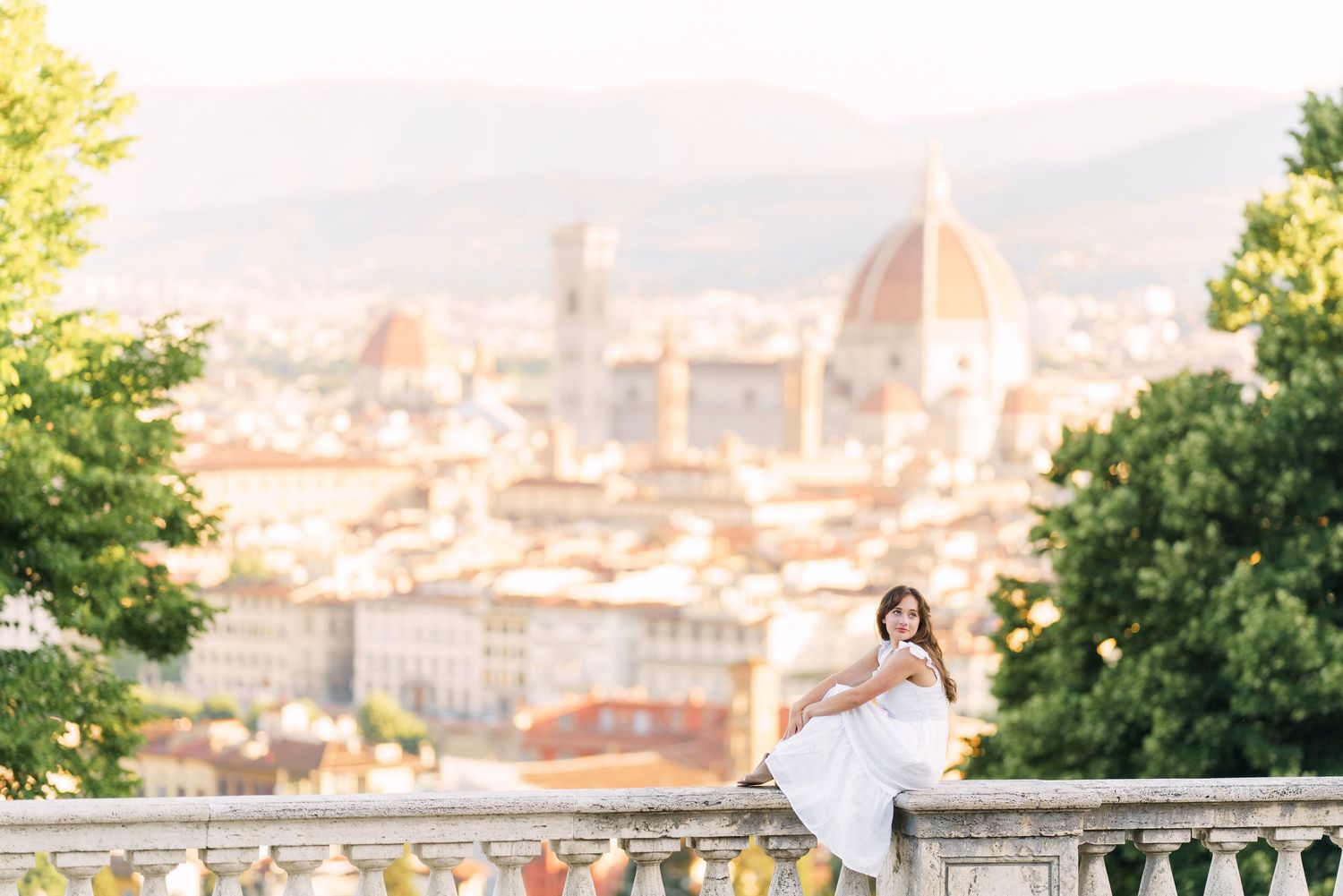 A panoramic view of Florence, Italy with the iconic Duomo cathedral dome rising above the historic cityscape at sunset.
