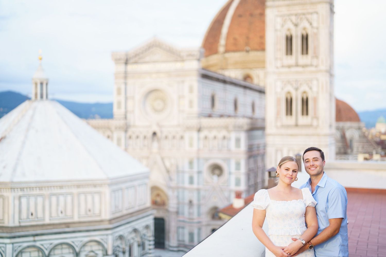 A romantic couple poses in front of Florence Cathedral and Duomo landmarks in Italy during sunset.