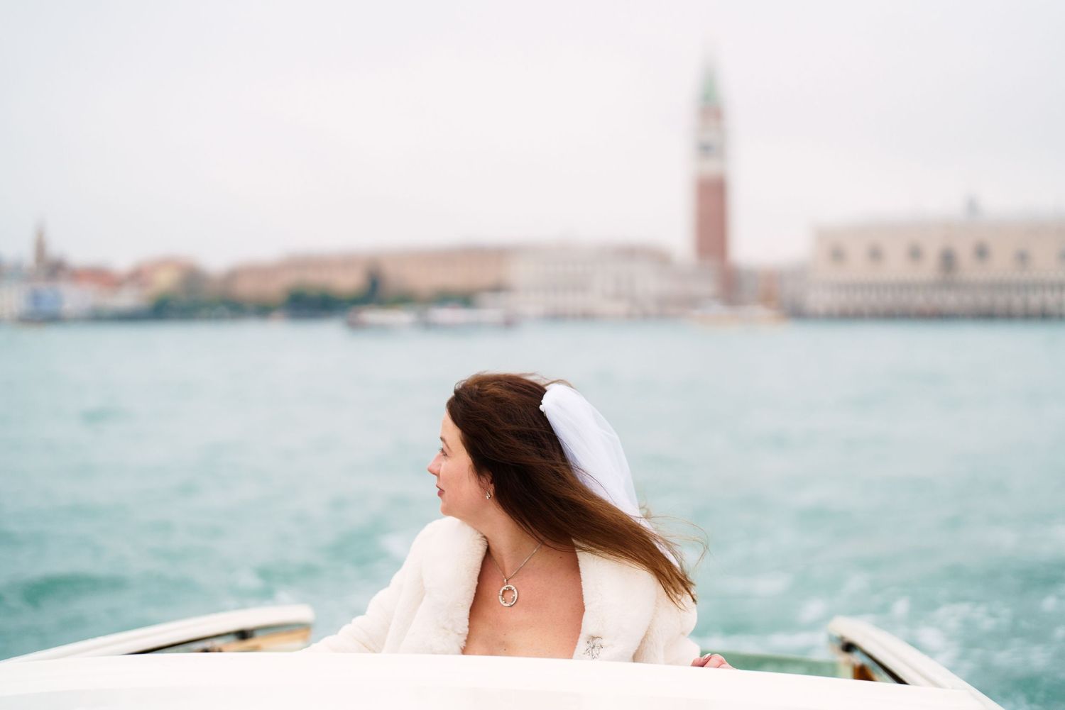 A boat ride through the turquoise waters of Venice with the iconic St. Mark's Campanile tower visible in the distance.
