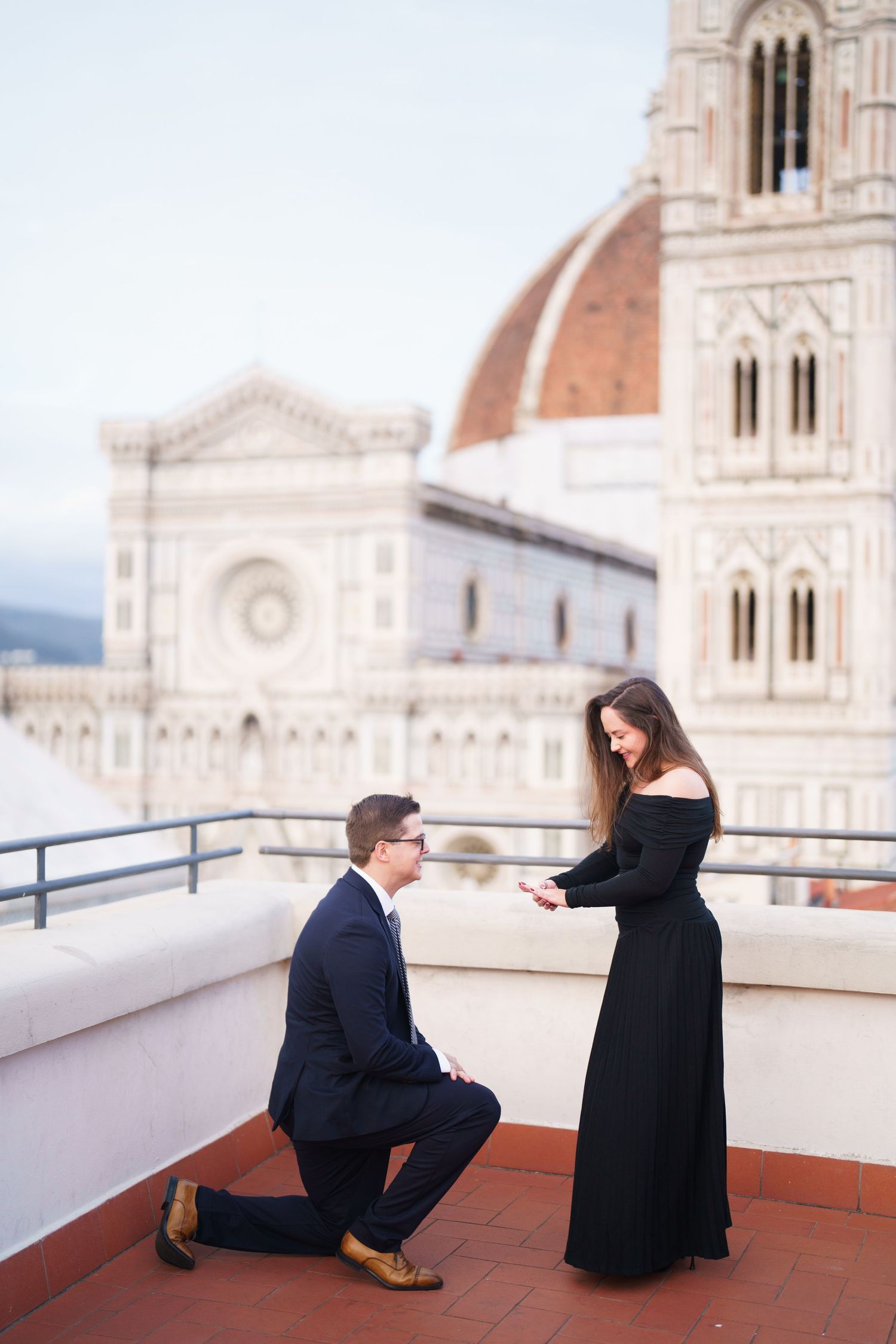 A couple sits on a terrace overlooking the historic Duomo cathedral in Florence, Italy.