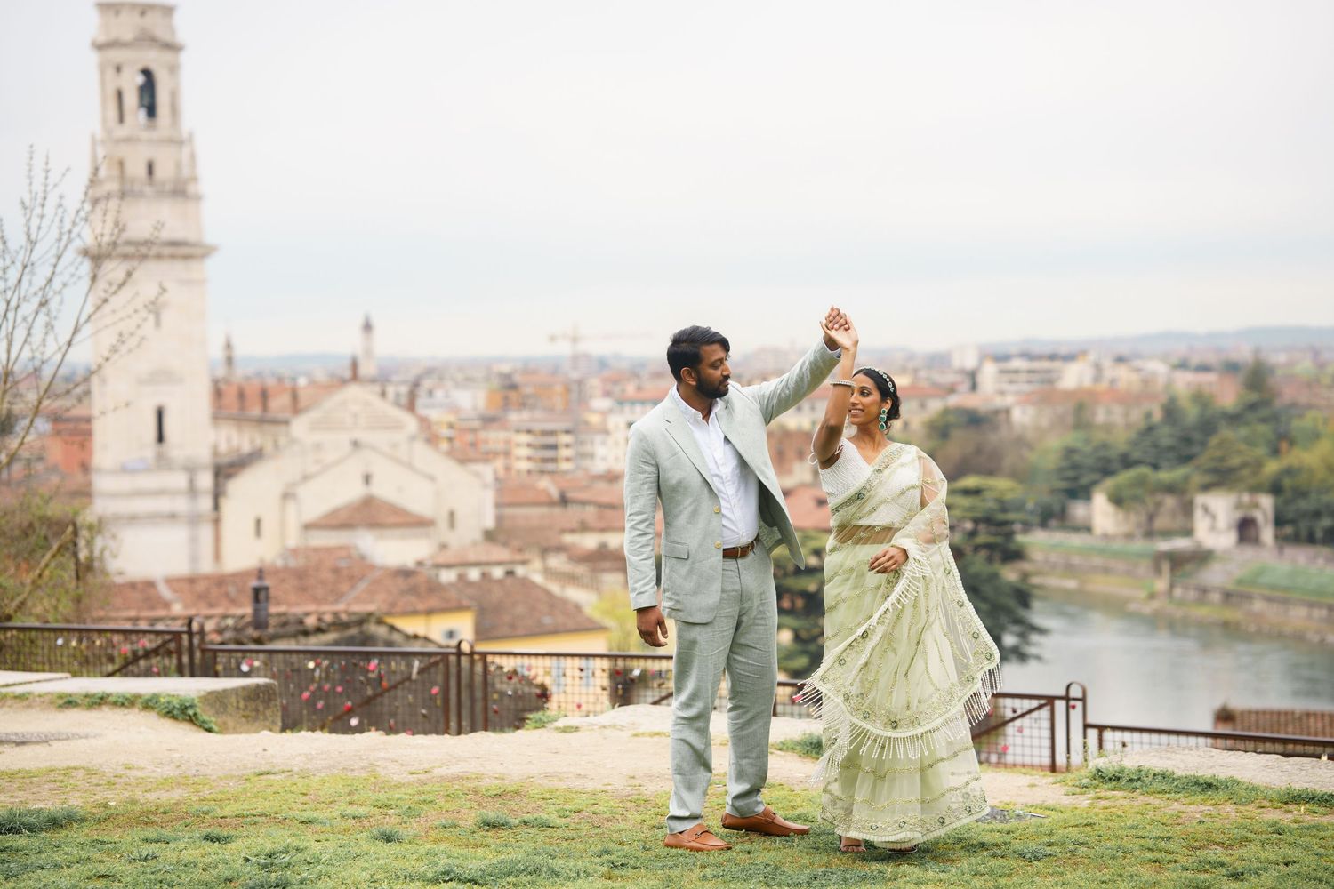 Romantic couple dancing and posing along historic Italian cityscape with river views in Florence.