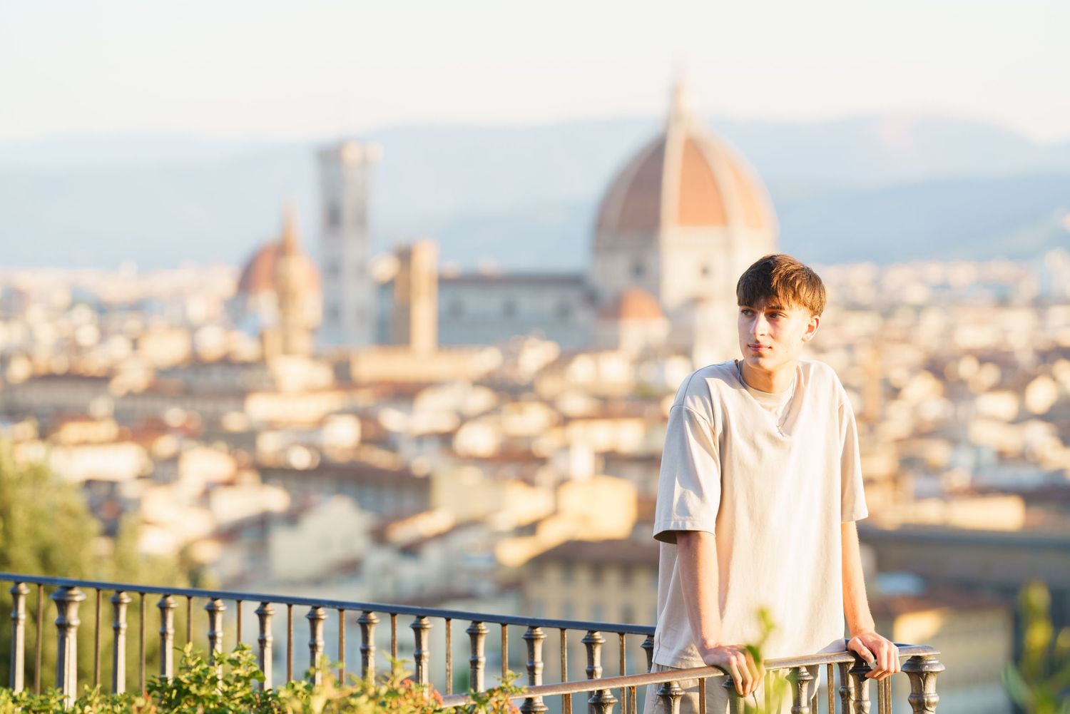 A couple enjoys a romantic sunset view of Florence, Italy from a scenic terrace overlooking the historic cityscape.