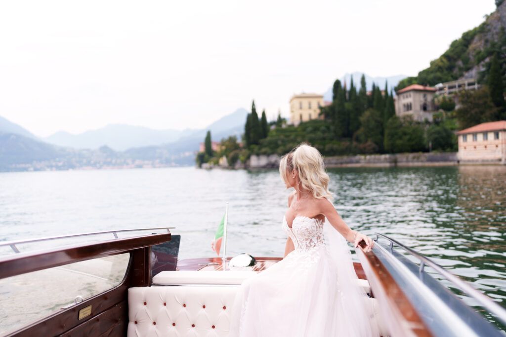 Beautiful waterfront terrace with stone columns and flowering plants along Lake Como.