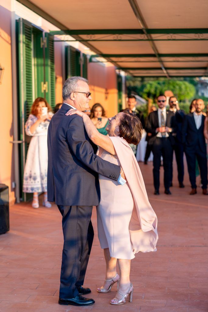 Couples dancing on a terrace during sunset at an elegant wedding reception.