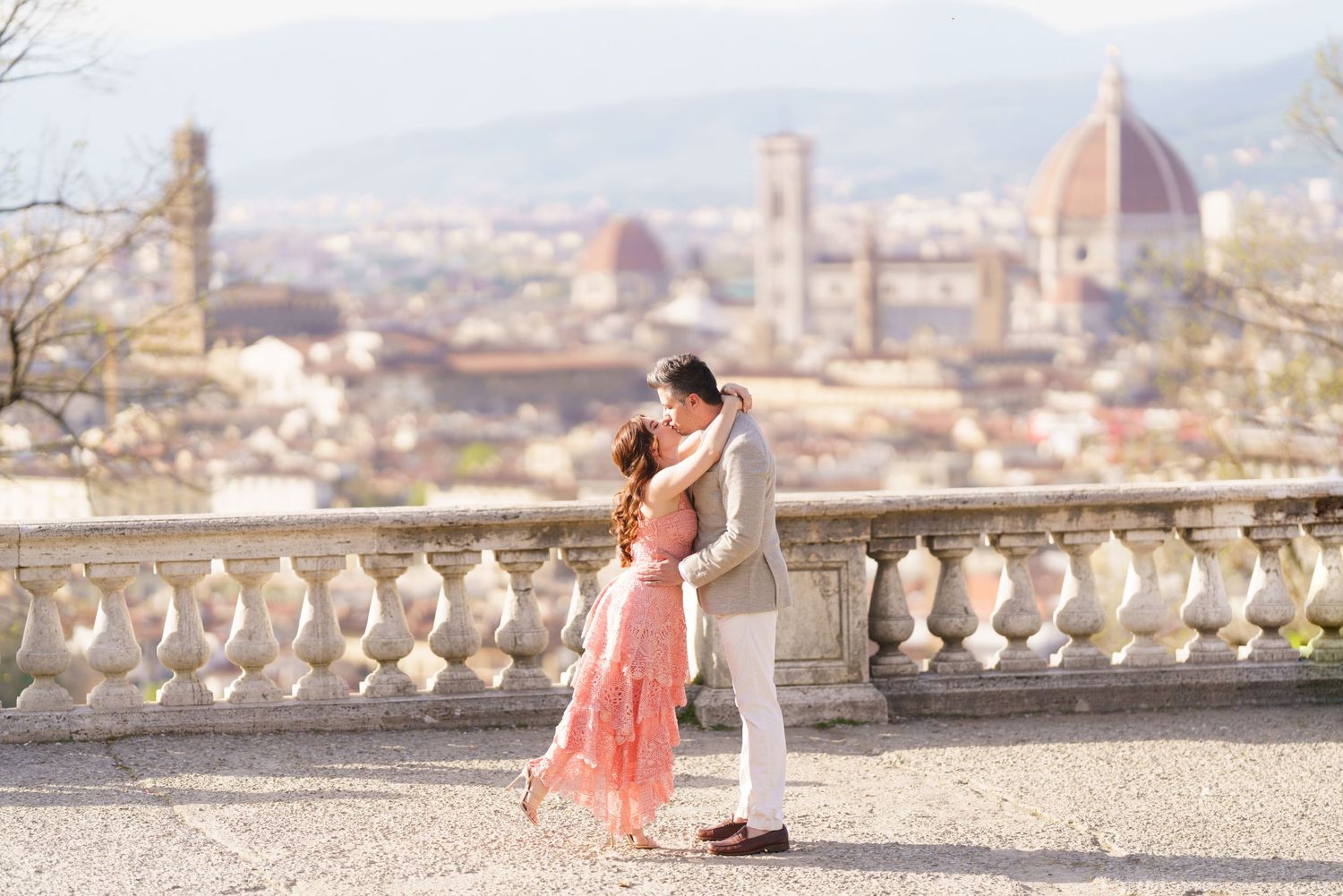 Romantic proposal moment at a scenic overlook in Florence, Italy with the Duomo cathedral visible in the background.