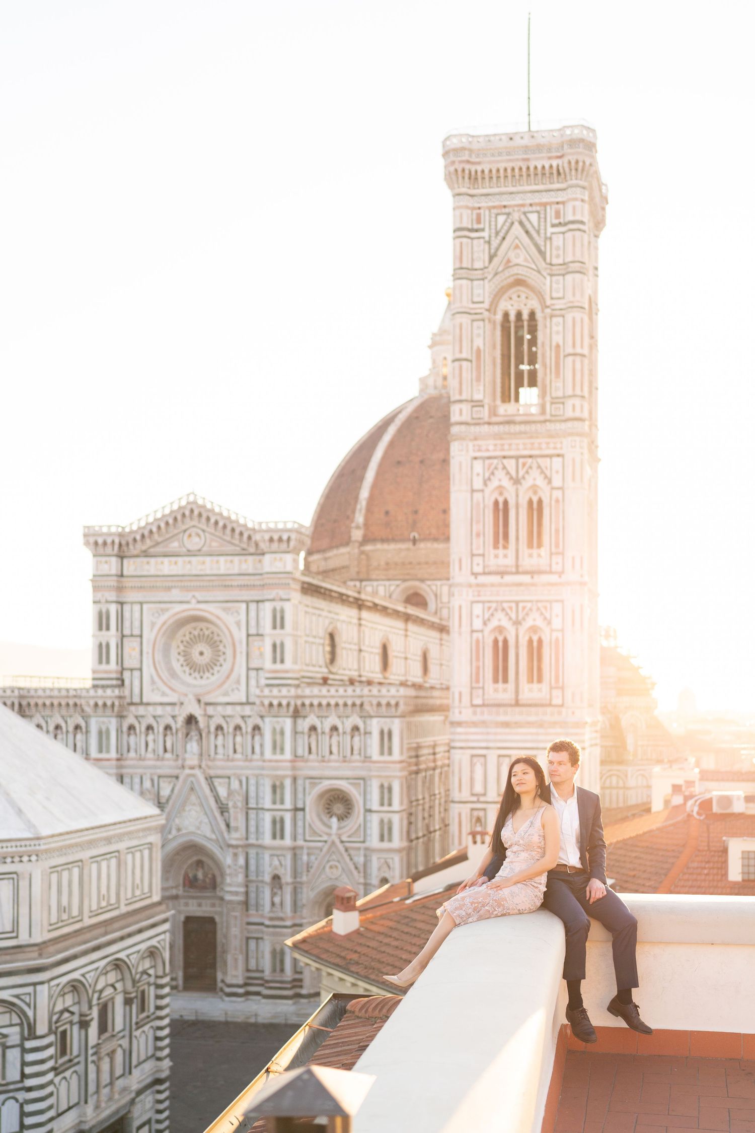 A couple shares a romantic moment at sunset overlooking Florence Cathedral's iconic Duomo in Italy.