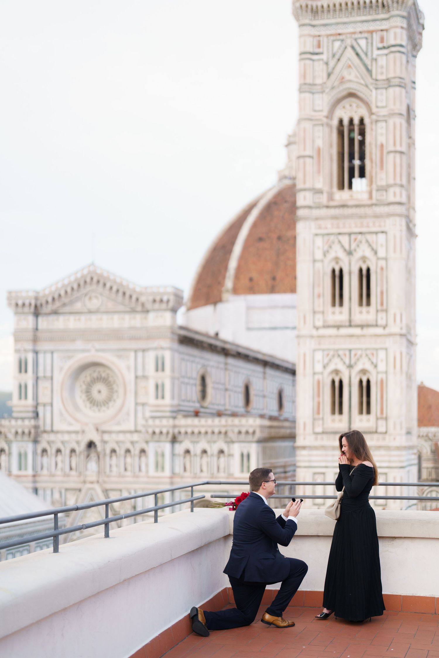 Two people sit on a terrace overlooking the iconic Florence Cathedral and its famous Duomo in Italy.