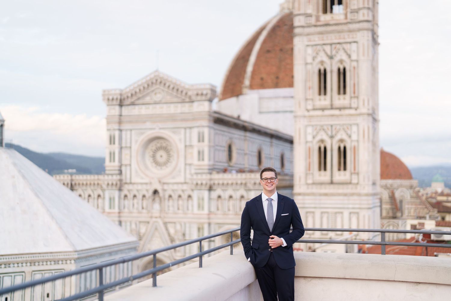 View of the iconic Florence Cathedral with its Renaissance dome and marble facade in the background on a cloudy day.