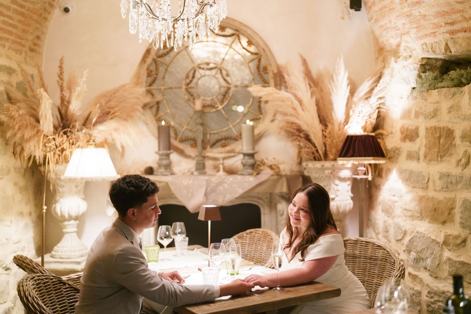 Wedding reception in a romantic vaulted cellar with crystal chandeliers and brick walls.