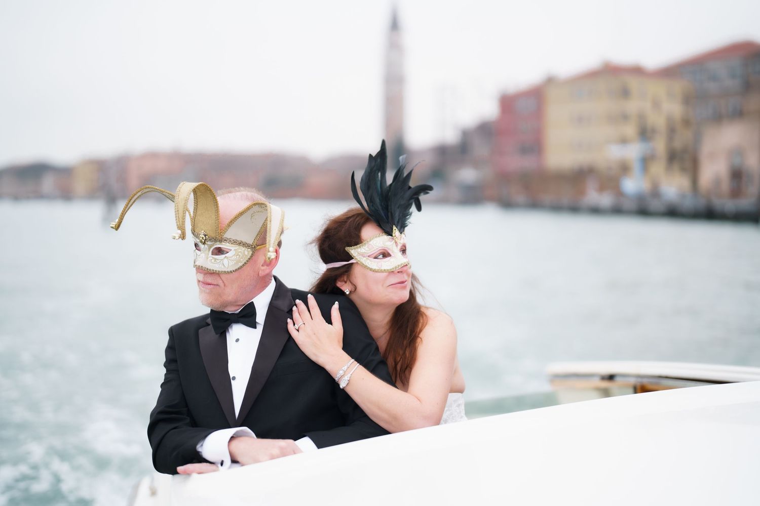 A romantic couple embraces during their wedding photoshoot along a scenic waterfront in Venice, Italy.
