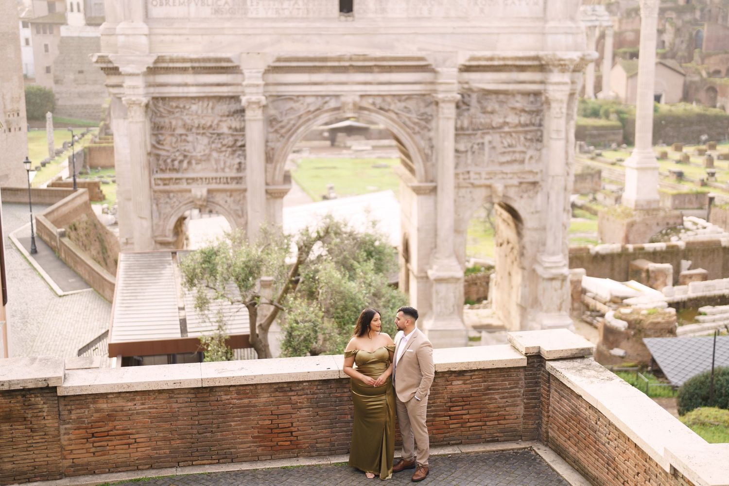 Couple embracing in front of the Arch of Septimius Severus at the Roman Forum in Rome, Italy.