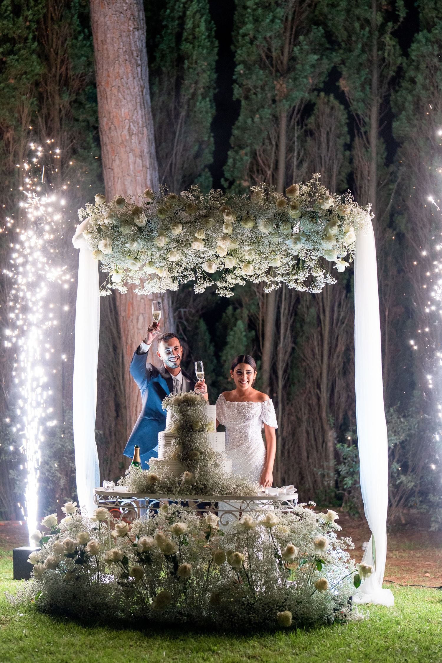 An enchanted forest wedding setup with illuminated trees and floral decorations.