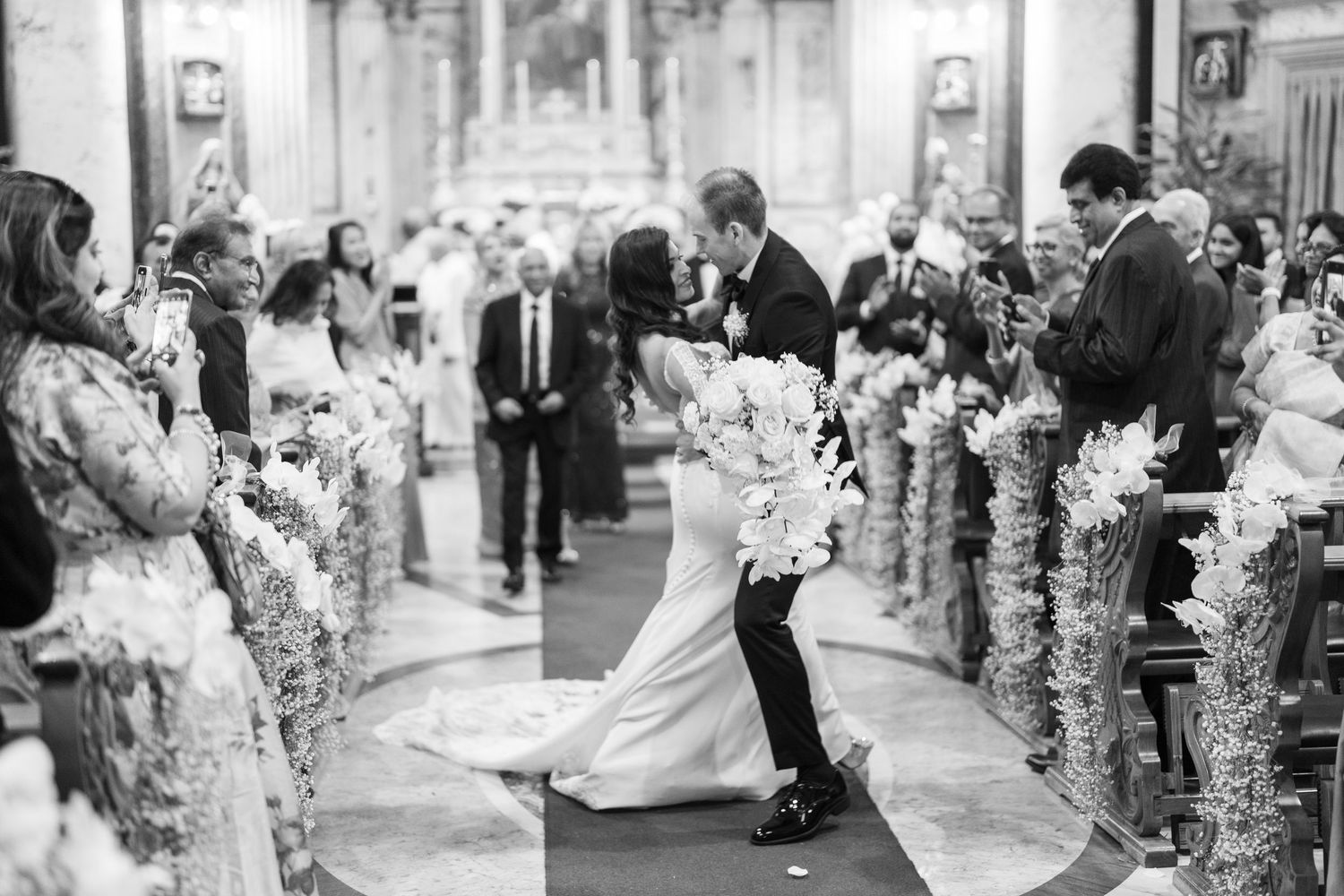 A black and white photo of a wedding ceremony in a traditional church setting.