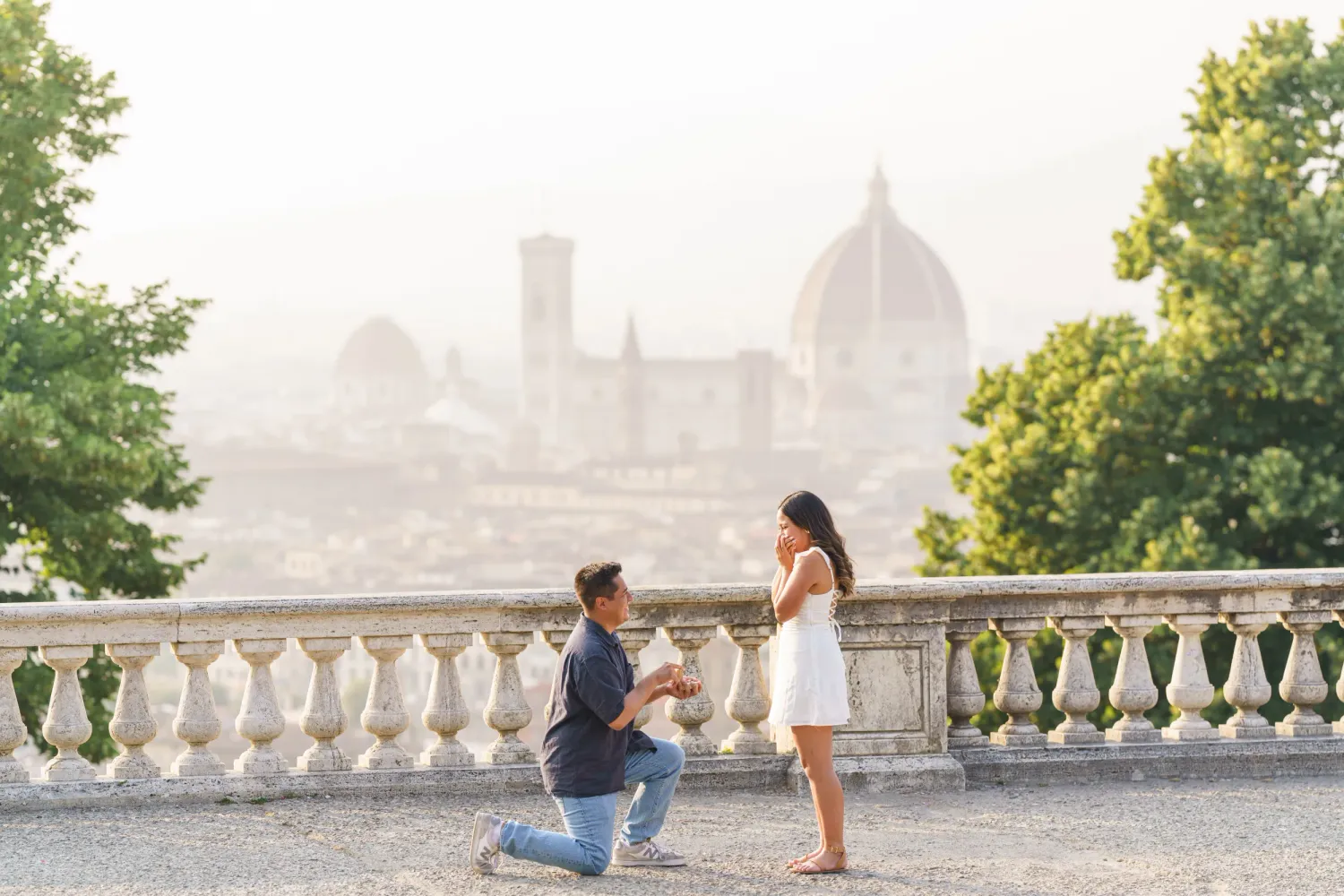 Couple enjoying a romantic moment at a scenic overlook with Florence Cathedral and city skyline in the background.