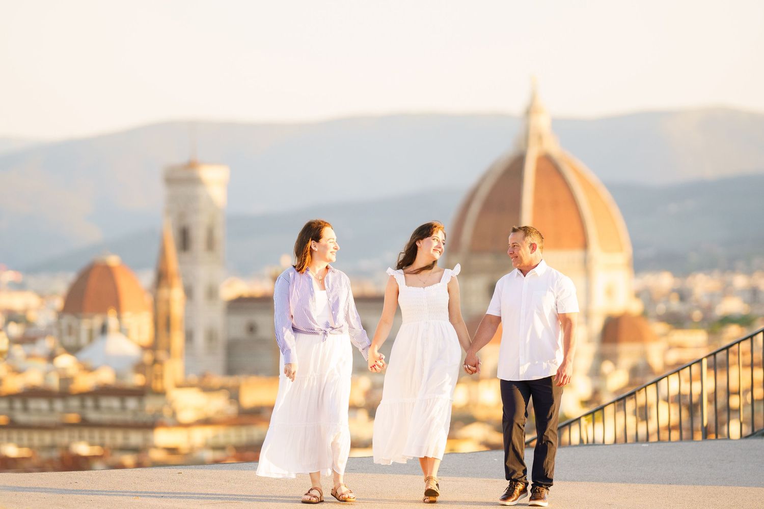 photographer Florence lPeople enjoying sunset views of Florence's iconic Duomo and cityscape from Piazzale Michelangelo viewpoint.