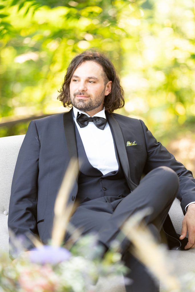 Formal attire worn at an elegant outdoor garden event with natural sunlit backdrop.