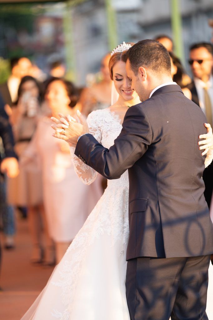 Wedding couple dancing together in a sequence of romantic moves on a terrace.