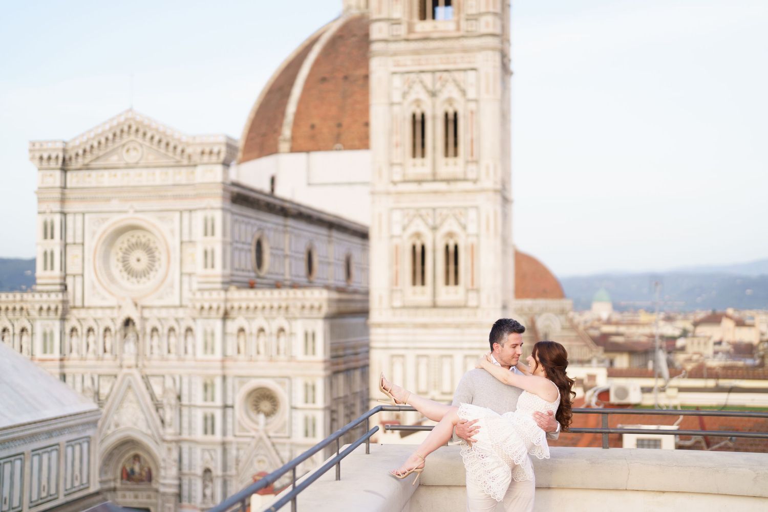 A bride in a white dress twirls joyfully in front of the historic Florence Cathedral in Italy.
