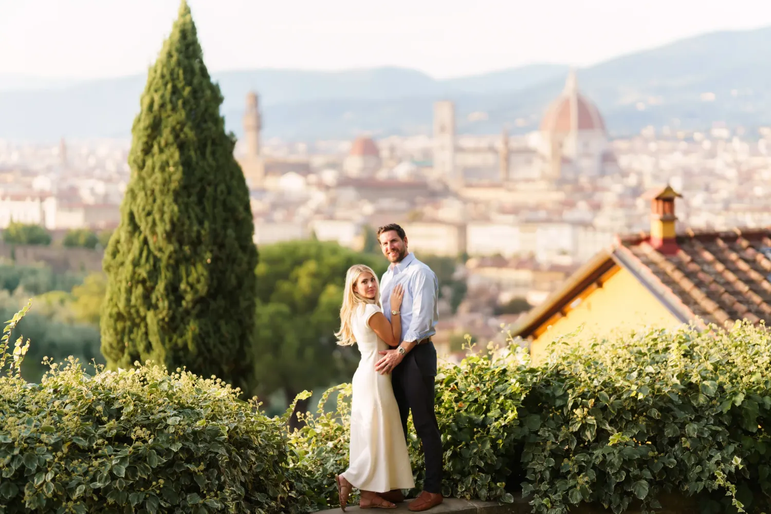 Scenic panoramic view of Florence Italy with historic architecture and cypress trees in the foreground.