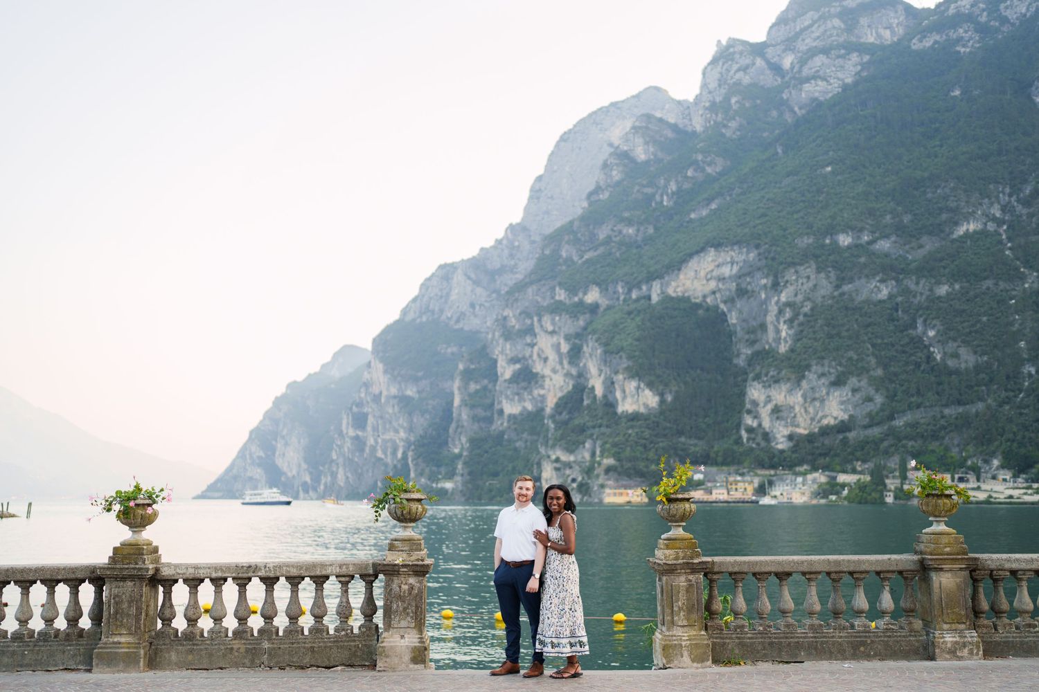 Engaged couple embracing beside Lake Garda during their Riva del Garda proposal session