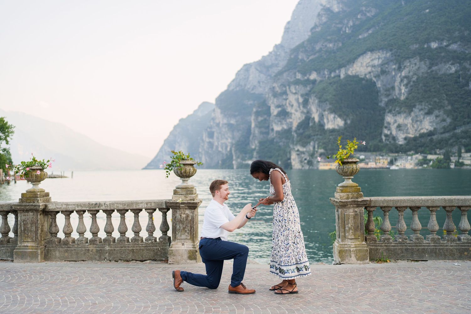 Engaged couple embracing beside Lake Garda during their Riva del Garda proposal session