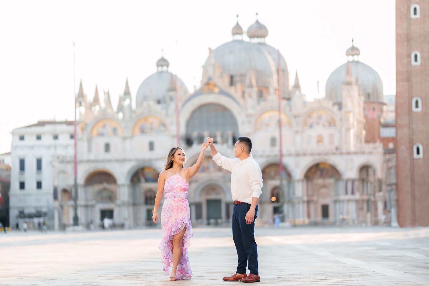 Couple dancing in St. Mark's Square, Venice, with the iconic Basilica di San Marco in the background.