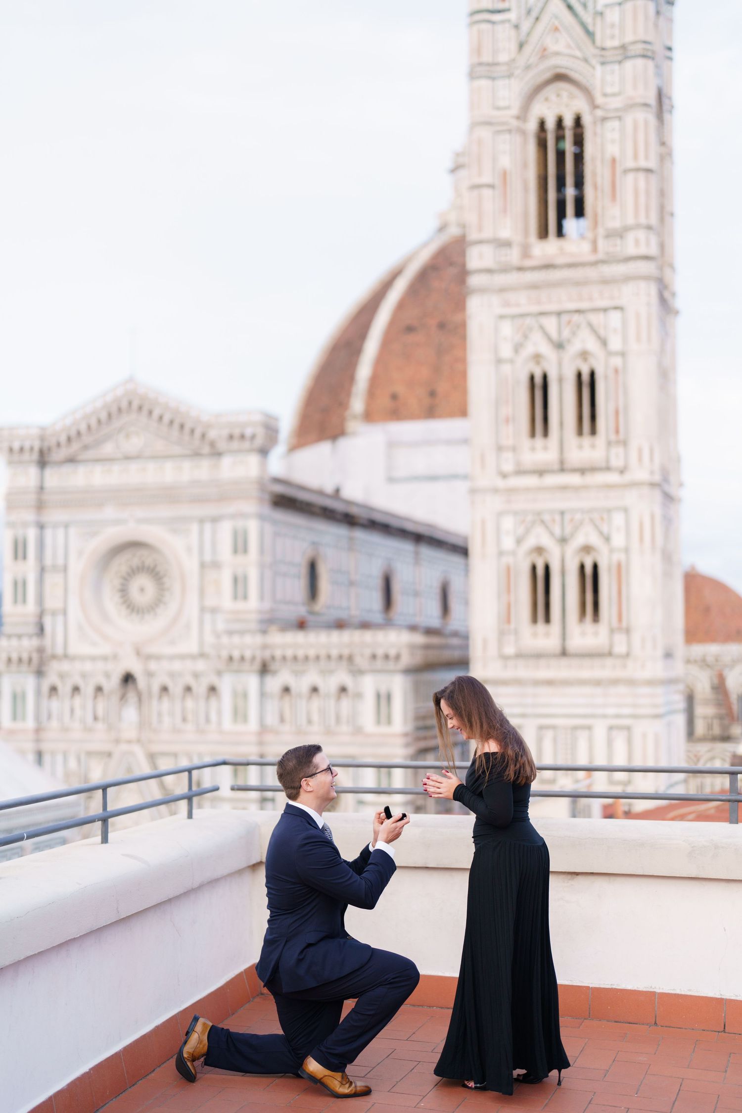 A romantic proposal moment on a rooftop terrace overlooking the Florence Cathedral and Giotto's Bell Tower in Italy.
