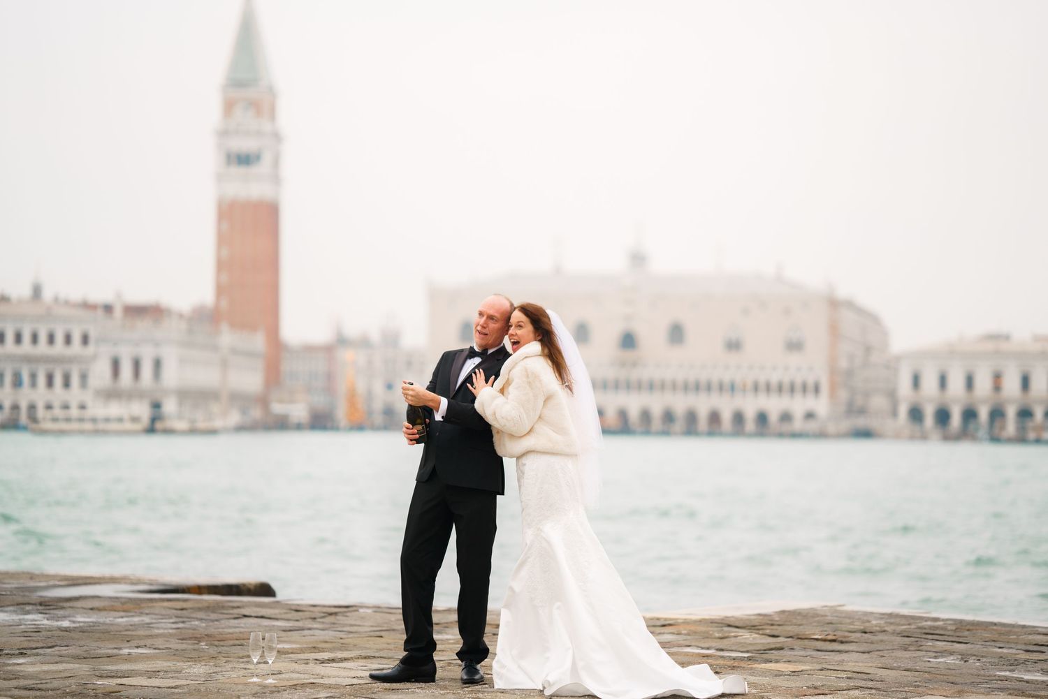 Romantic couple embraces during their wedding photoshoot along the Venice canals with historic architecture in background.
