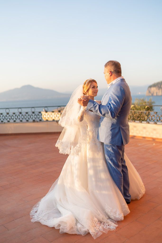 Romantic dance sequence on a Mediterranean terrace with mountain views at sunset.