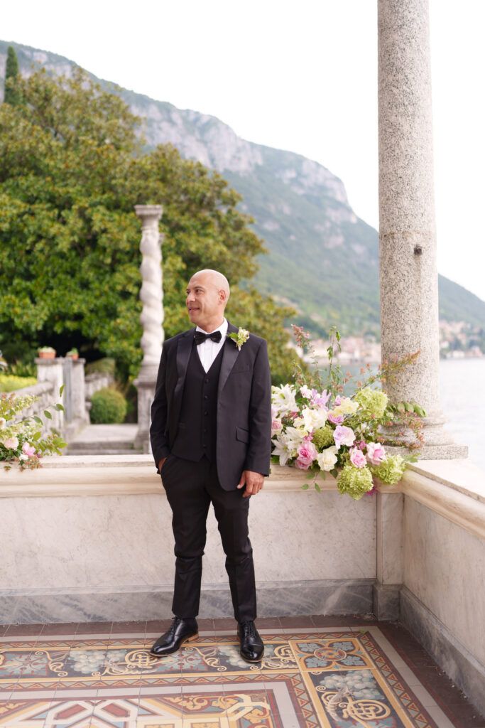 Classic Italian villa terrace with stone columns and decorative tile flooring overlooking Lake Como.
